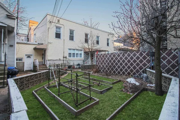 a view of a backyard with couches chair and wooden fence