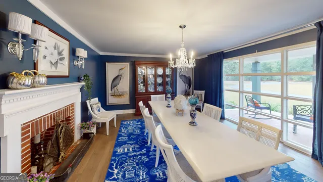 a view of a dining room with furniture a chandelier and wooden floor
