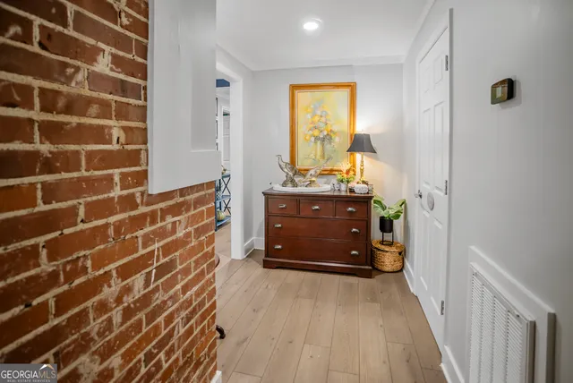 a view of a hallway with wooden floor and staircase