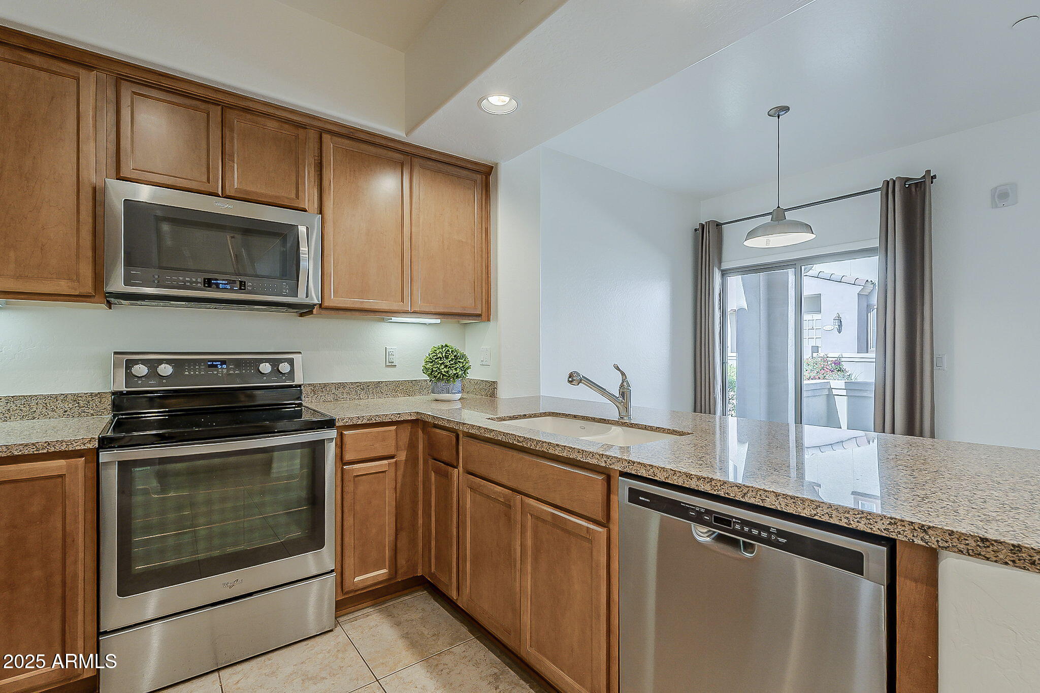 3935 East Rough Rider Road, Unit 1264 Phoenix, AZ 85050 - Photo 4 of 40 a kitchen with granite countertop cabinets stainless steel appliances and a sink