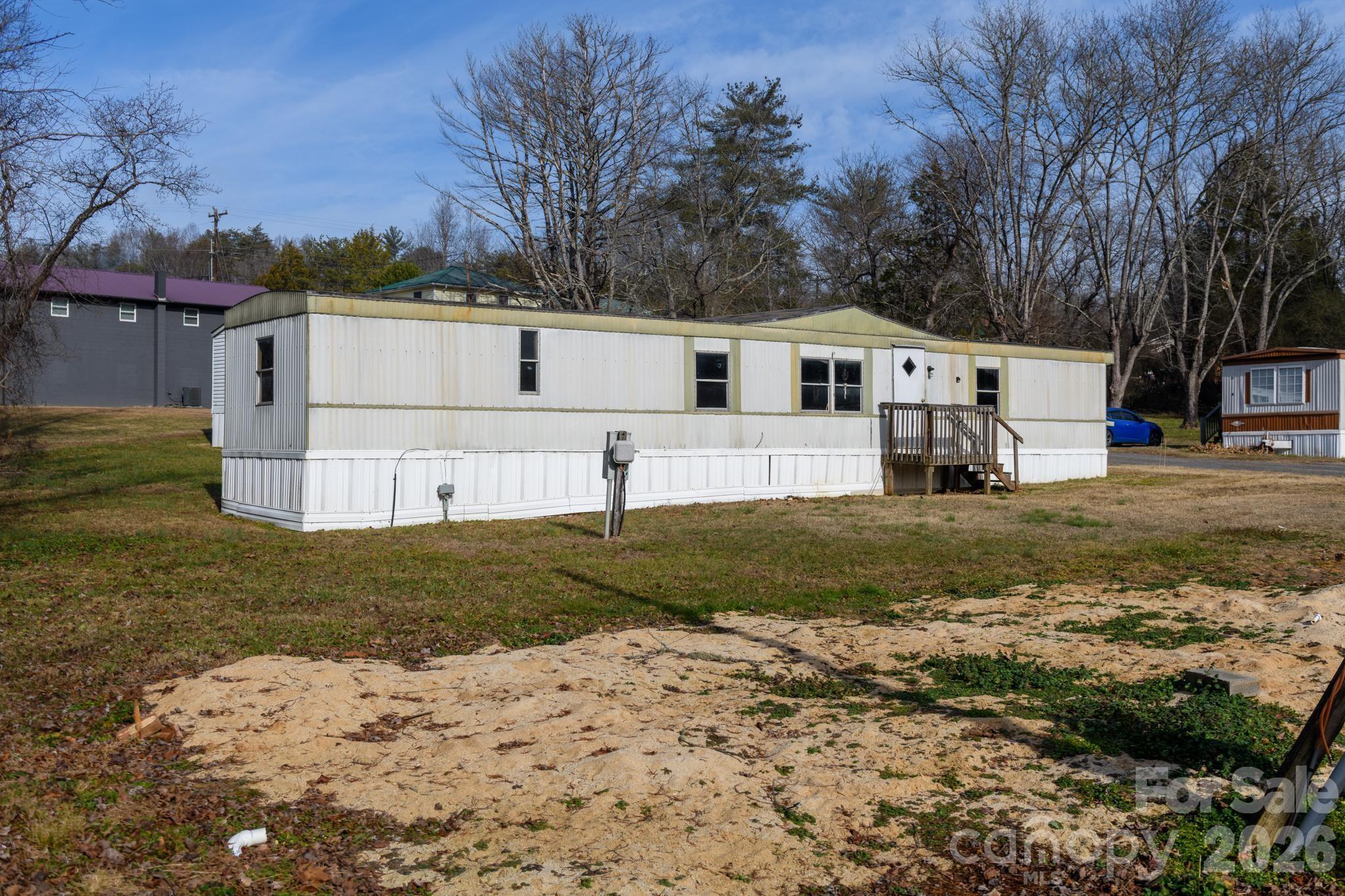 3036 Highway 18 Morganton, NC 28655 - Photo 9 of 28 a view of a white house that has a small yard and large trees