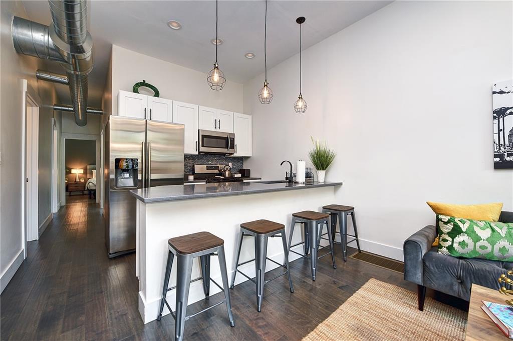 103 57th Street Pittsburgh, PA 15201 - Photo 2 of 49 a kitchen with stainless steel appliances granite countertop a kitchen island a stove a table and chairs