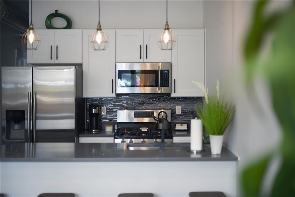 103 57th Street Pittsburgh, PA 15201 - Photo 21 of 49 a kitchen with stainless steel appliances granite countertop a refrigerator a stove and a wooden floor