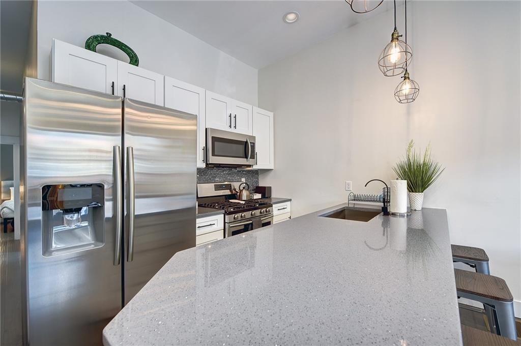 103 57th Street Pittsburgh, PA 15201 - Photo 29 of 49 a kitchen with a refrigerator a stove and a dining table