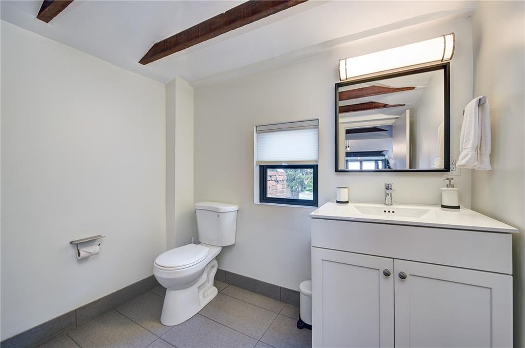 103 57th Street Pittsburgh, PA 15201 - Photo 44 of 49 a bathroom with a toilet sink and mirror