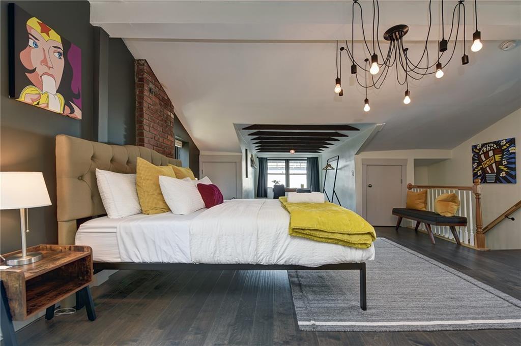 103 57th Street Pittsburgh, PA 15201 - Photo 46 of 49 a bedroom with a bed a dresser and potted plants with the wooden floor