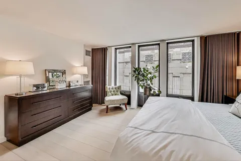 a large bedroom with a large bed and windows