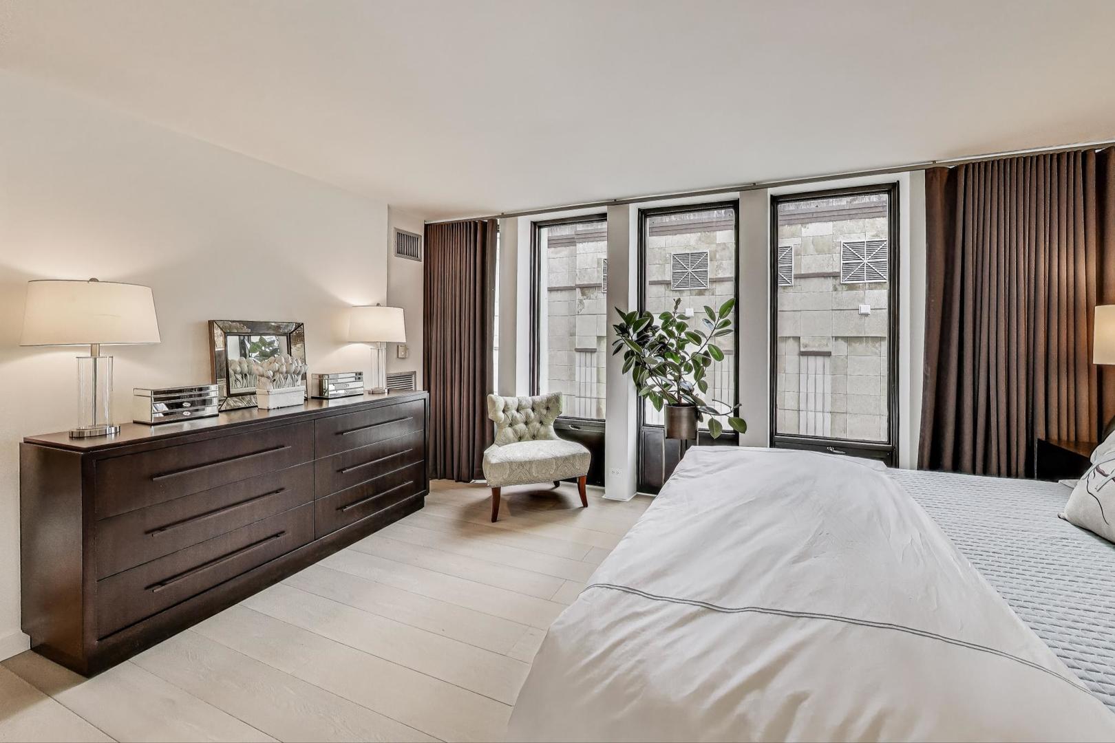 100 East Walton Street, Unit 15DE Chicago, IL 60611 - Photo 16 of 26 a large bedroom with a large bed and windows
