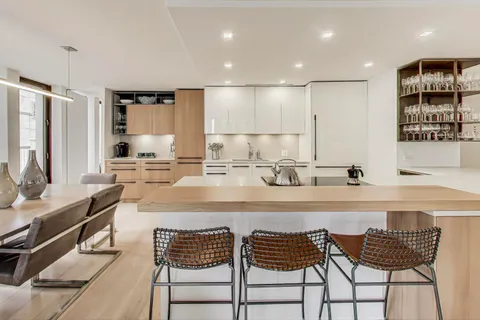 a kitchen with a sink and chairs