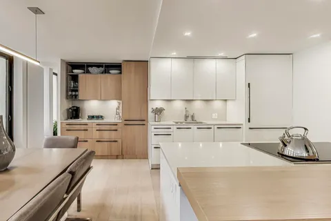 a kitchen with a refrigerator a sink and white cabinets