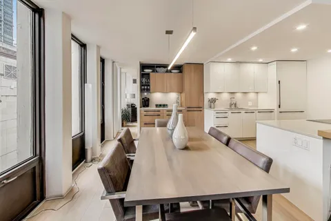 a kitchen with stainless steel appliances refrigerator dining table and chairs