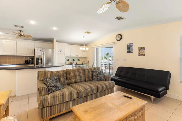 a kitchen with stainless steel appliances granite countertop a dining table chairs and a refrigerator