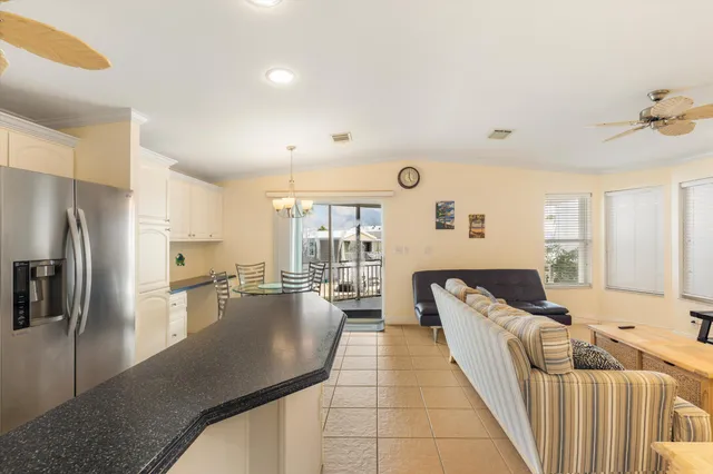 a kitchen with stainless steel appliances granite countertop a refrigerator a stove a sink and white cabinets with wooden floor