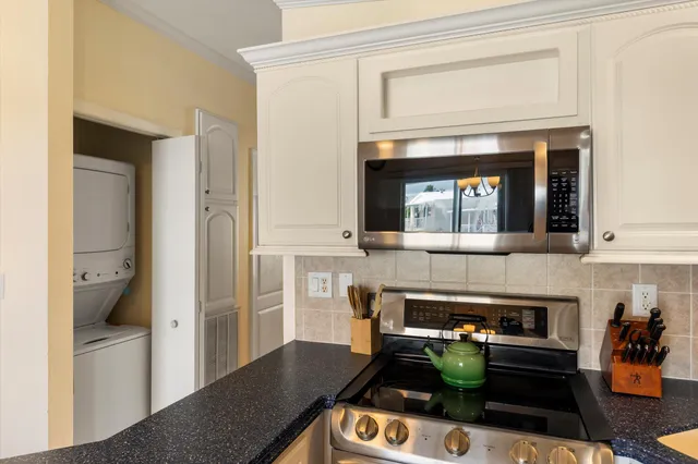 a bedroom with a bed a dresser and a chandelier