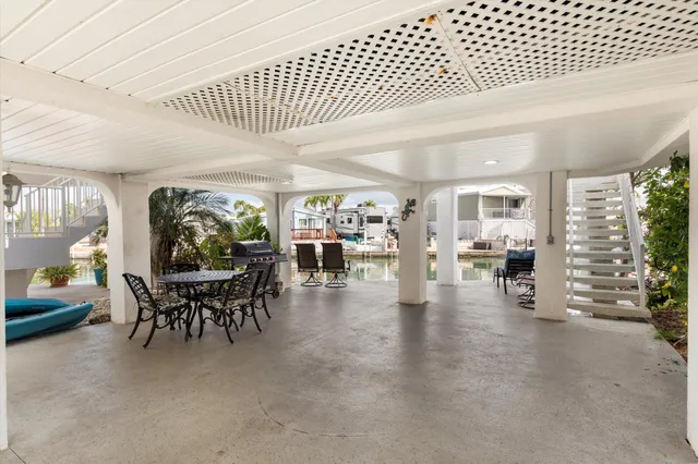 a living room with furniture kitchen view and a chandelier