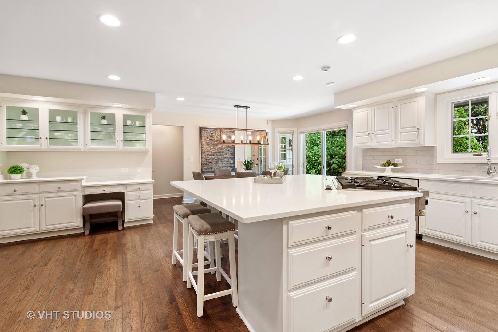 25 South County Line Road Hinsdale, IL 60521 - Photo 8 of 44 a kitchen with kitchen island granite countertop a stove a sink a dining table and chairs with wooden floor