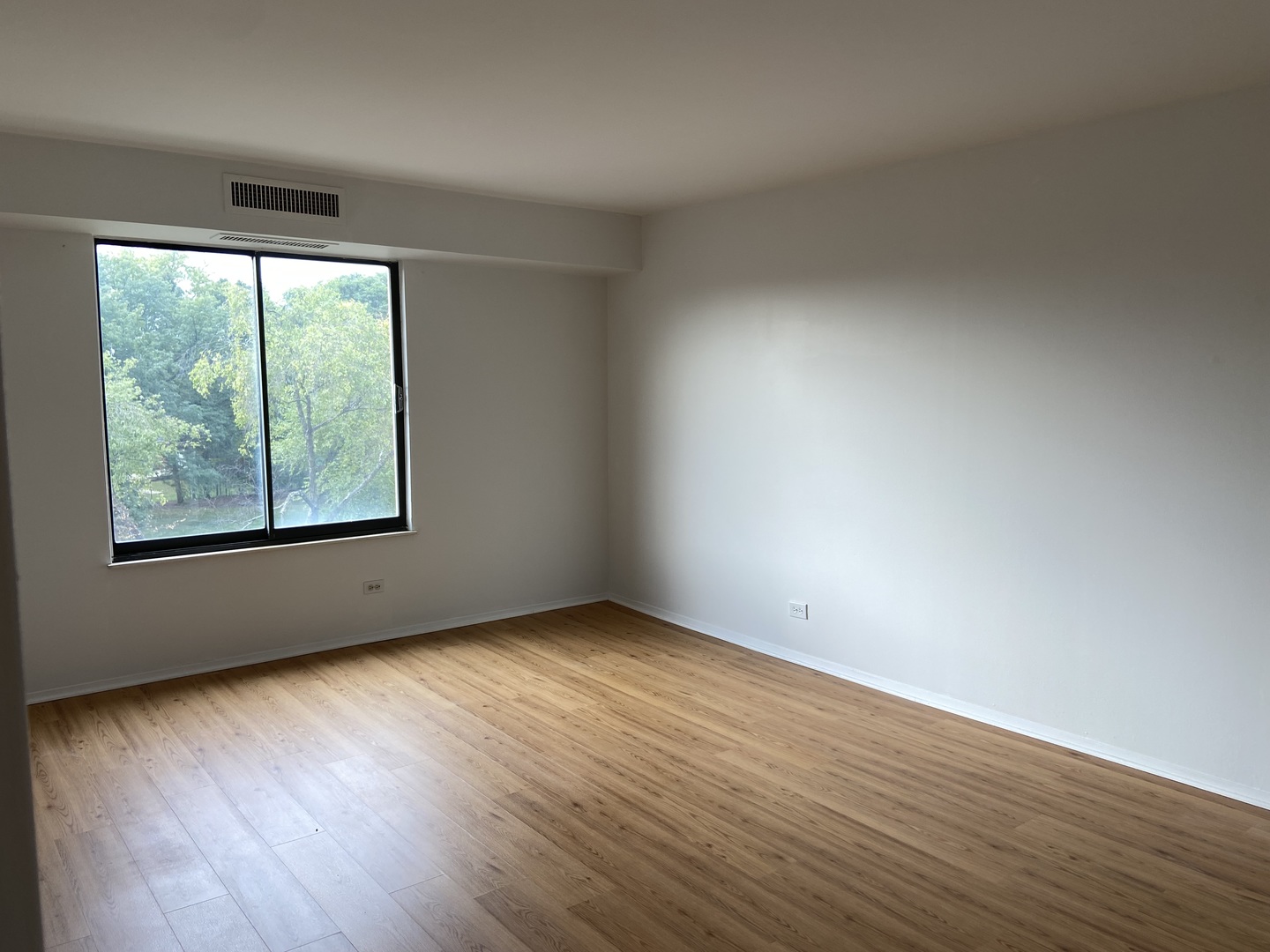 1605 East Central Road, Unit 410B Arlington Heights, IL 60005 - Photo 11 of 18 an empty room with wooden floor and windows