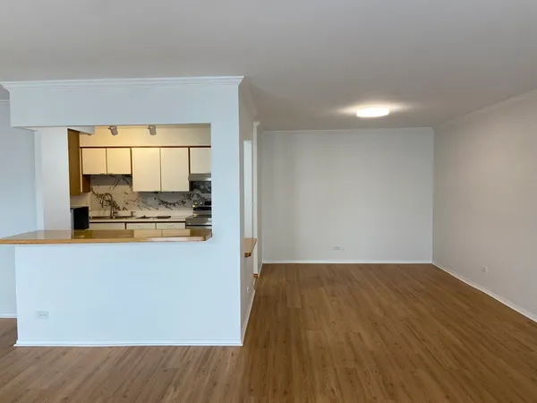 a view of a kitchen with wooden floor and a sink