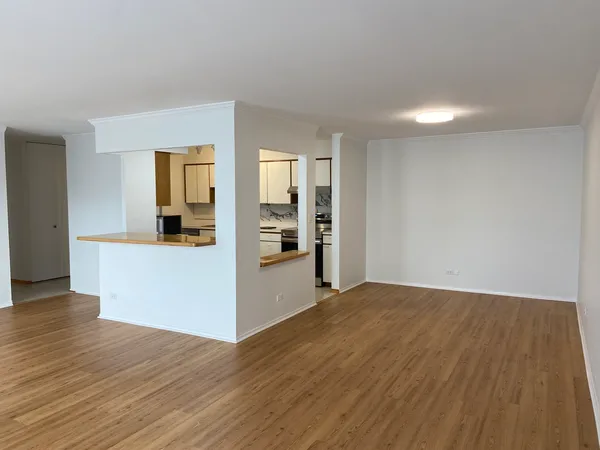 a view of empty room with wooden floor