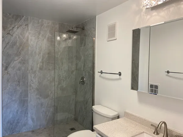 a bathroom with a toilet a sink and shower