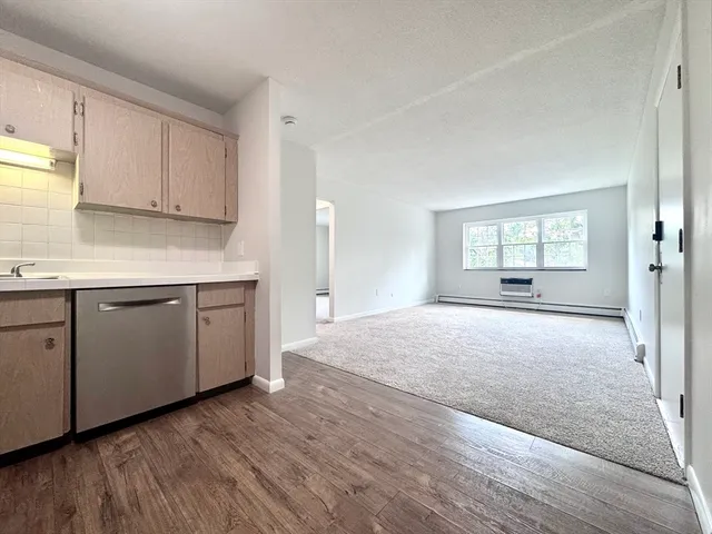 a open kitchen with cabinets and wooden floors