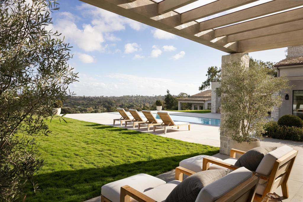 17845 Via De Fortuna Rancho Santa Fe, CA 92067 - Photo 32 of 45 a view of a swimming pool and lounge chairs in back yard of the house