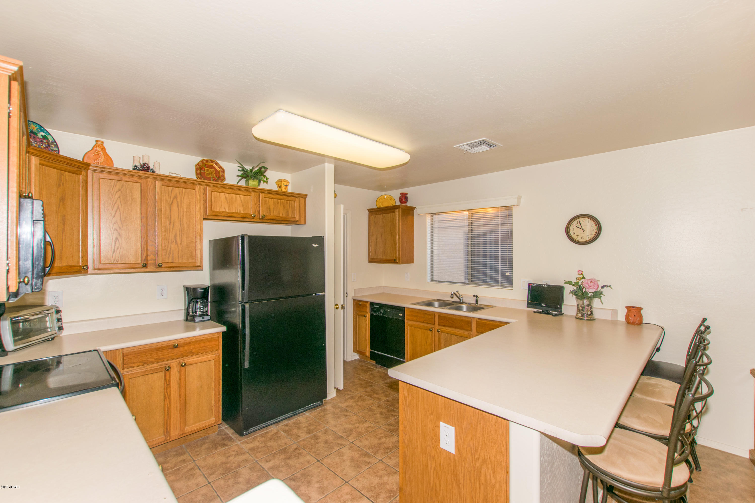 43902 West Magnolia Road Maricopa, AZ 85138 - Photo 10 of 34 a kitchen with refrigerator and cabinets