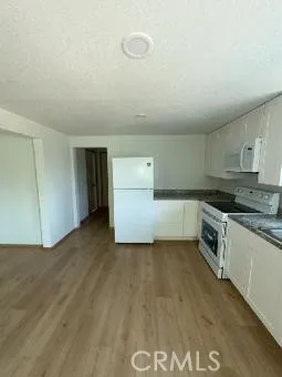 a kitchen with a refrigerator and white cabinets