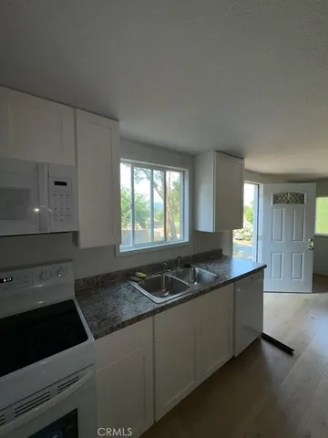 a kitchen with granite countertop a sink and a stove top oven