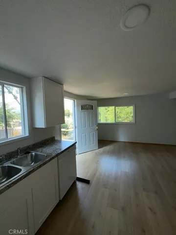 a kitchen with granite countertop a sink and a stove top oven
