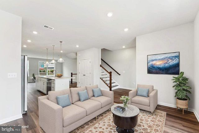 a living room with furniture and a view of kitchen