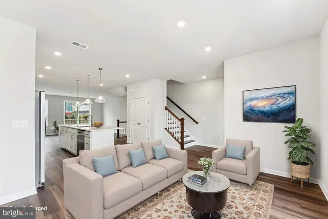 a living room with furniture and a view of kitchen