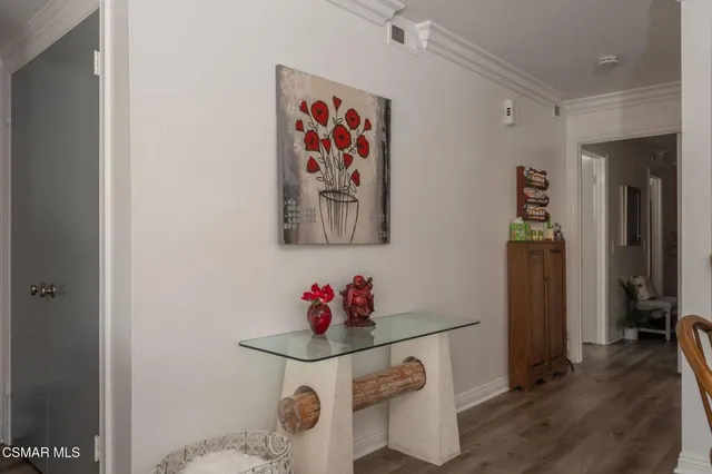 a view of a hallway with wooden floor and furniture