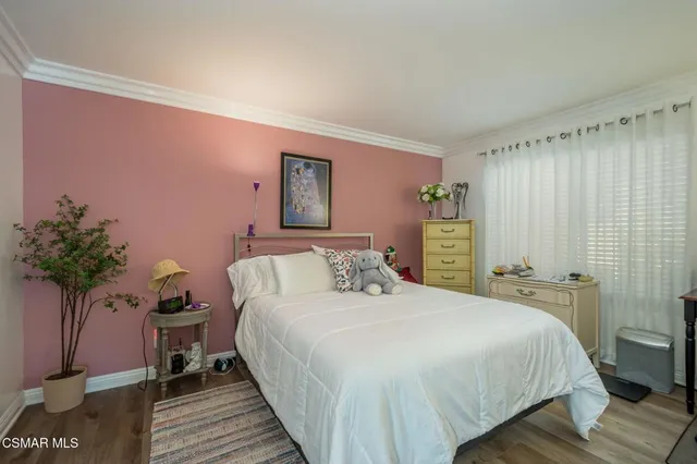 a bedroom with a bed and a potted plant