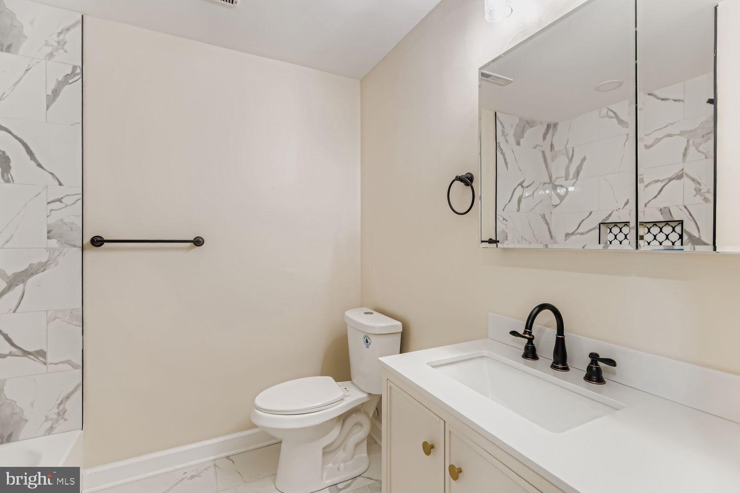 719 South Marlyn Avenue Baltimore, MD 21221 - Photo 18 of 39 a bathroom with a toilet sink and a mirror