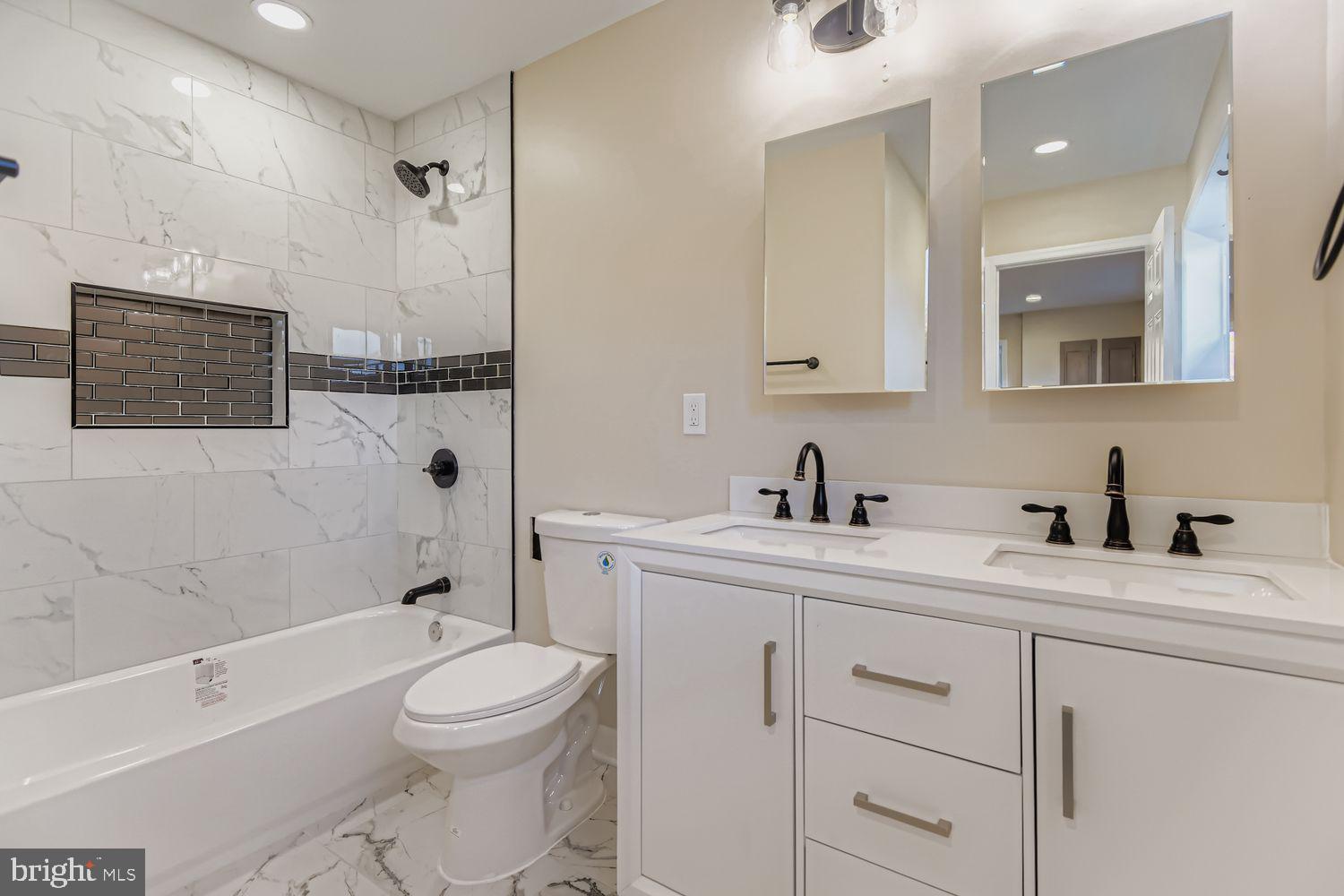 719 South Marlyn Avenue Baltimore, MD 21221 - Photo 26 of 39 a bathroom with a toilet a sink a mirror a bathtub and vanity