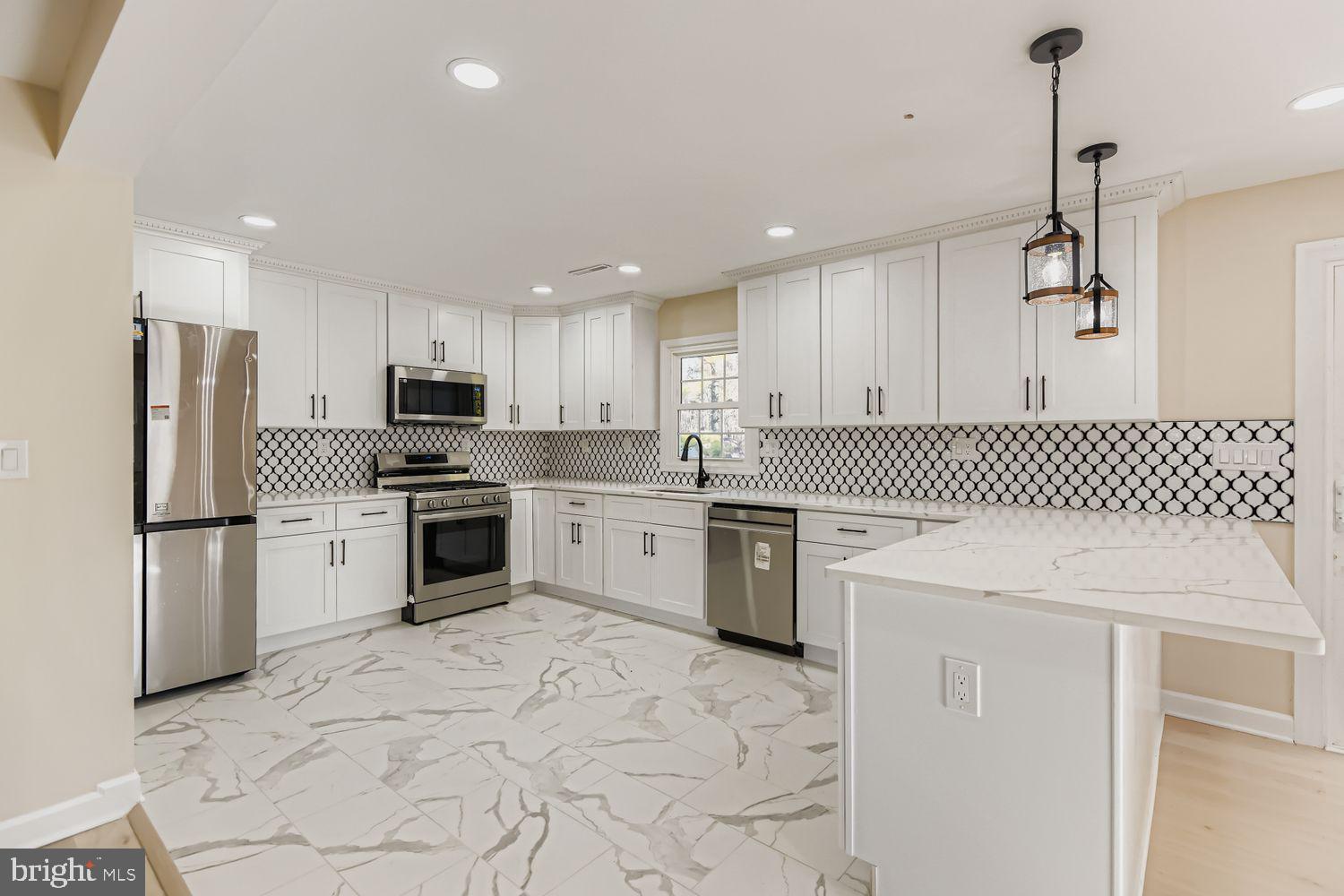 719 South Marlyn Avenue Baltimore, MD 21221 - Photo 5 of 39 a kitchen with white cabinets and stainless steel appliances
