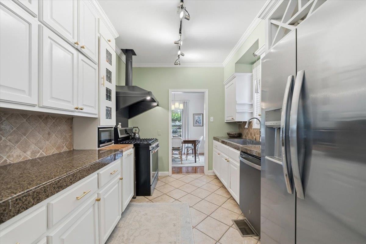 160 Picardy Street Memphis, TN 38111 - Photo 18 of 38 a kitchen with stainless steel appliances granite countertop a refrigerator a stove and white cabinets with granite countertops
