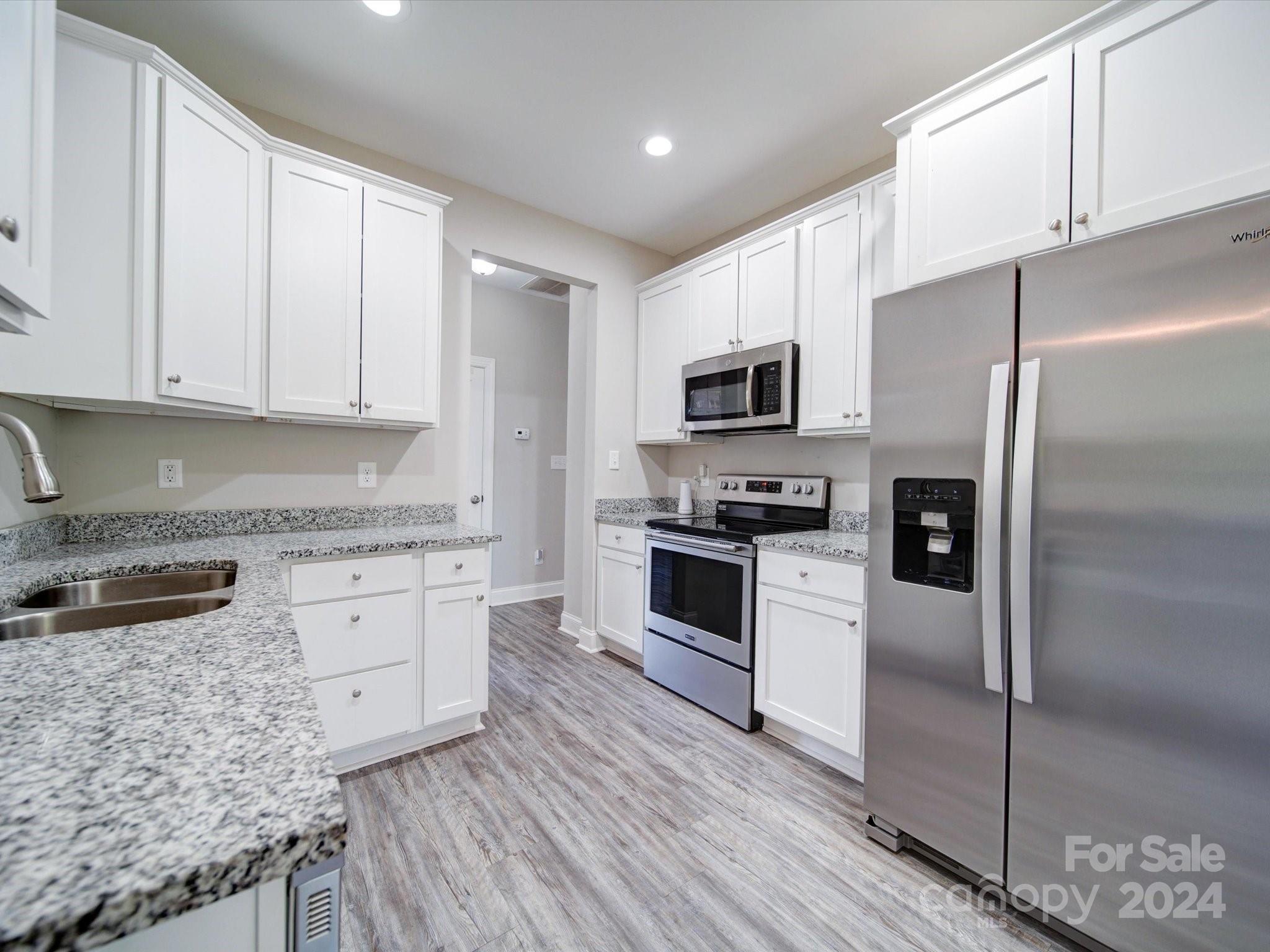 962 Miles Road Dallas, NC 28034 - Photo 9 of 35 a kitchen with granite countertop a refrigerator stove and microwave