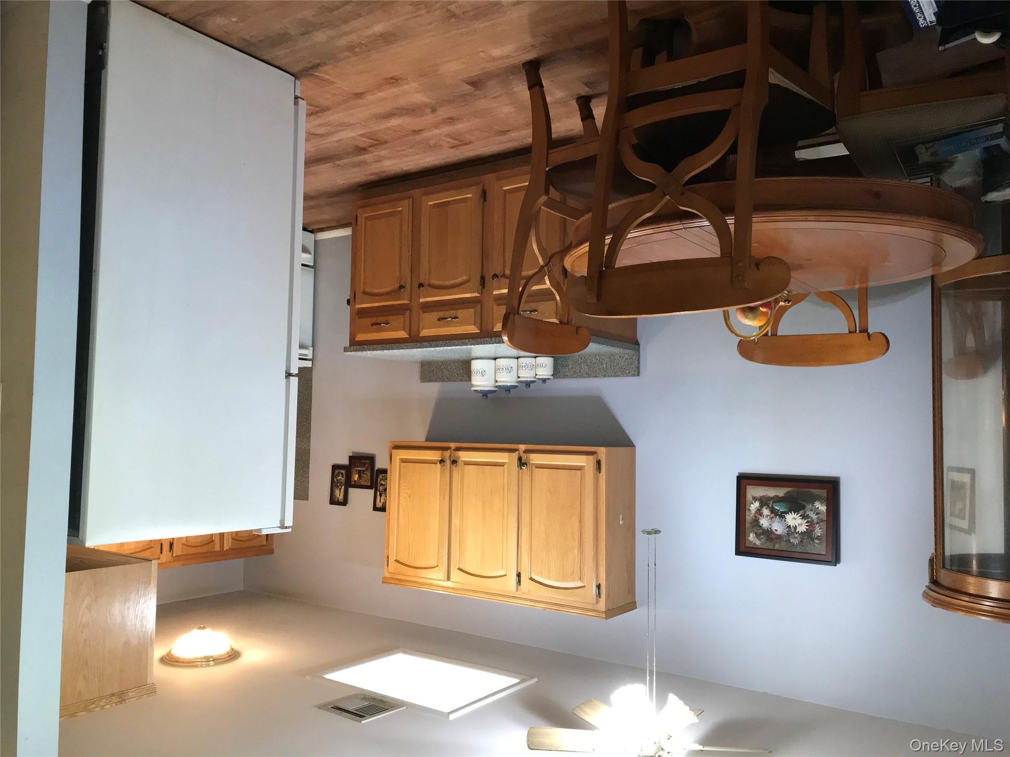 405 Woodbridge Drive, Unit D Ridge, NY 11961 - Photo 3 of 13 a kitchen with stainless steel appliances granite countertop a dining table chairs refrigerator and sink