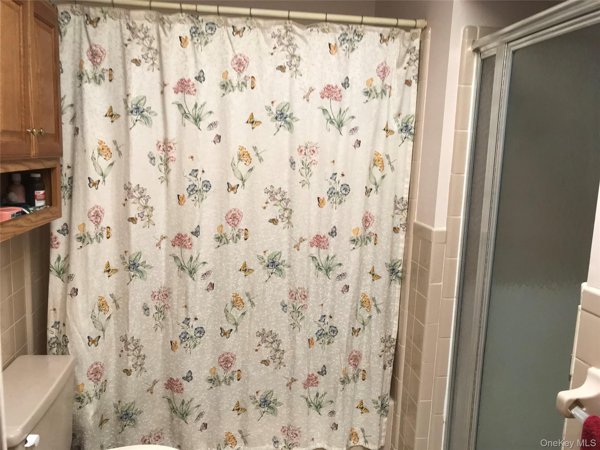 405 Woodbridge Drive, Unit D Ridge, NY 11961 - Photo 8 of 13 a bathroom with a shower curtain