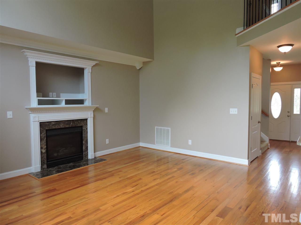 223 Fletcher Ridge Road Timberlake, NC 27583 - Photo 7 of 24 a view of an empty room with wooden floor fireplace and a window