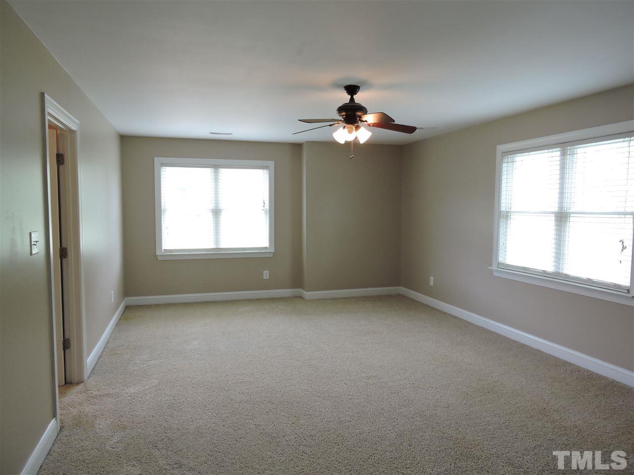 223 Fletcher Ridge Road Timberlake, NC 27583 - Photo 8 of 24 an empty room with windows and chandelier fan