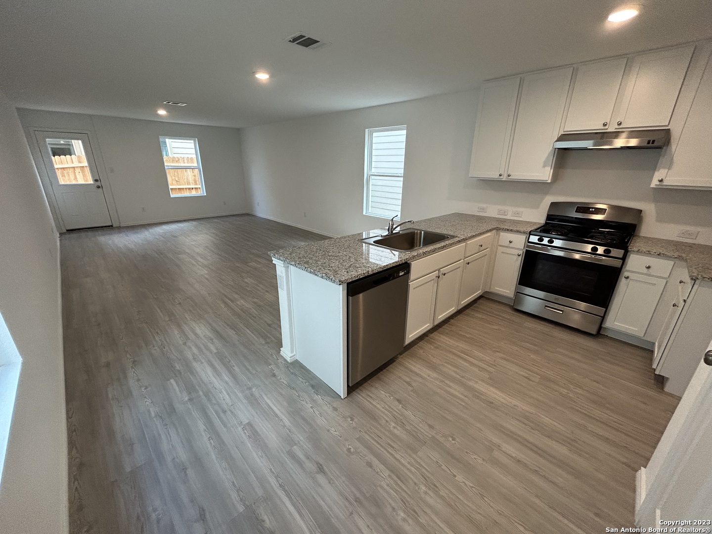 11026 Tree Line San Antonio, TX 78223 - Photo 5 of 31 a kitchen with granite countertop a stove top oven and cabinets
