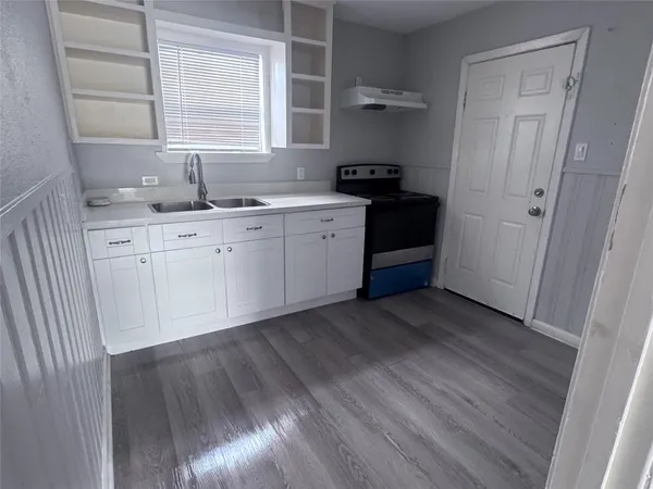 a kitchen with granite countertop white cabinets and white appliances