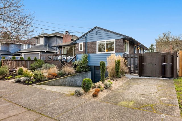 a front view of a house with a yard and potted plants