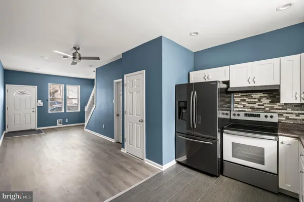 a kitchen with stainless steel appliances granite countertop a refrigerator sink and stove
