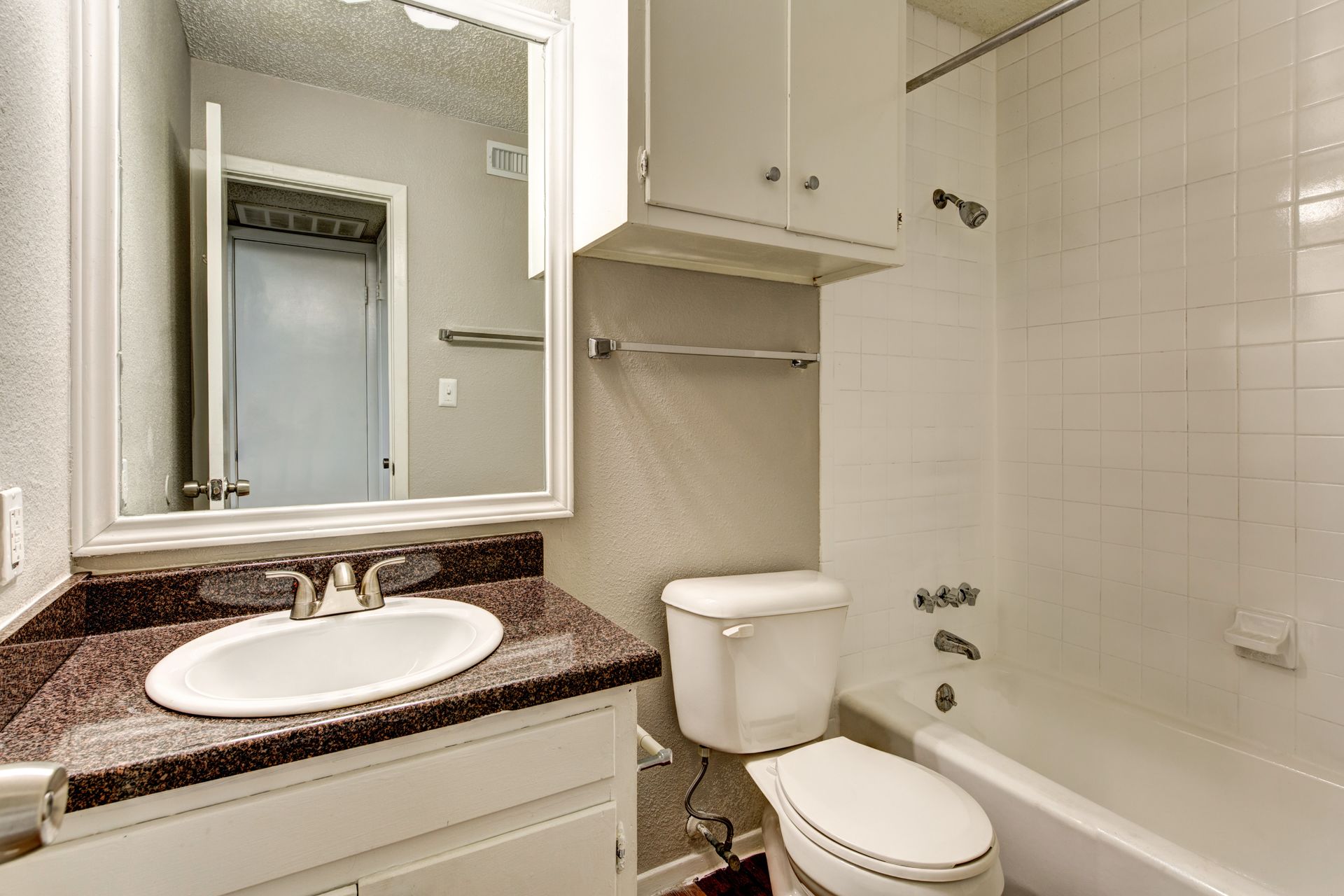 4510 Duval Street, Unit 204 Austin, TX 78751 - Photo 8 of 9 Bathroom featuring a vanity with a brown granite countertop, a white sink, and a white framed mirror