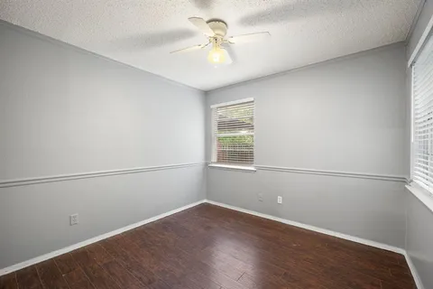 an empty room with a window and a ceiling fan