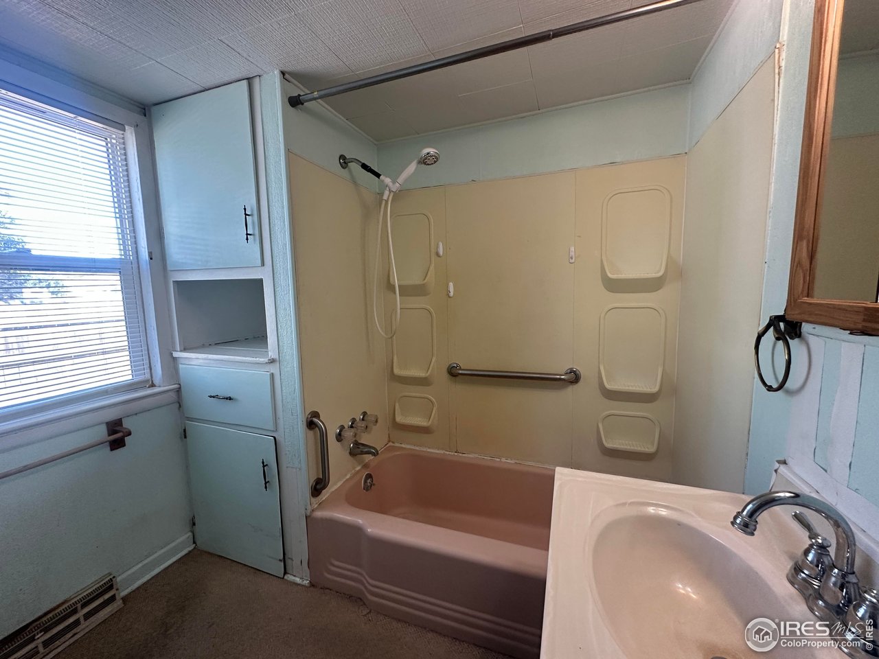 224 State Street Sterling, CO 80751 - Photo 16 of 23 a bathroom with a tub a sink and a window